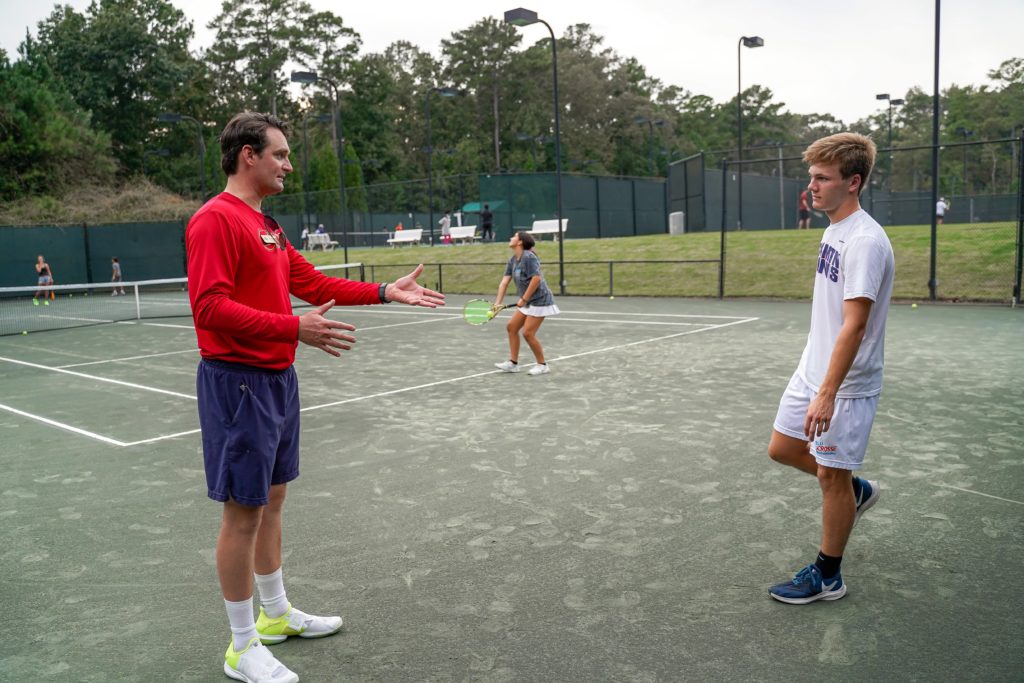 Tennis Coach JC Freeman with a junior